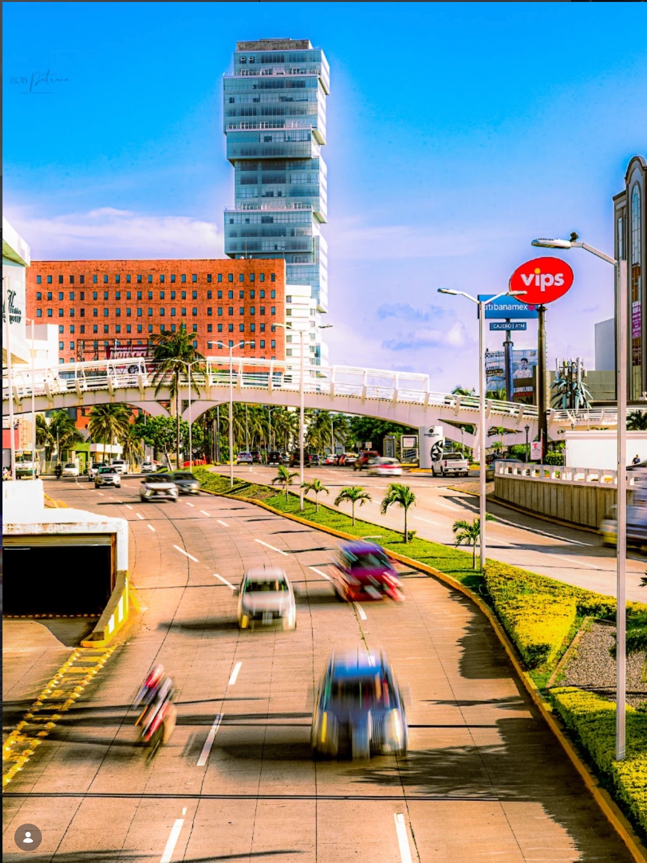 Modern avenue with tall buildings and motion blur cars