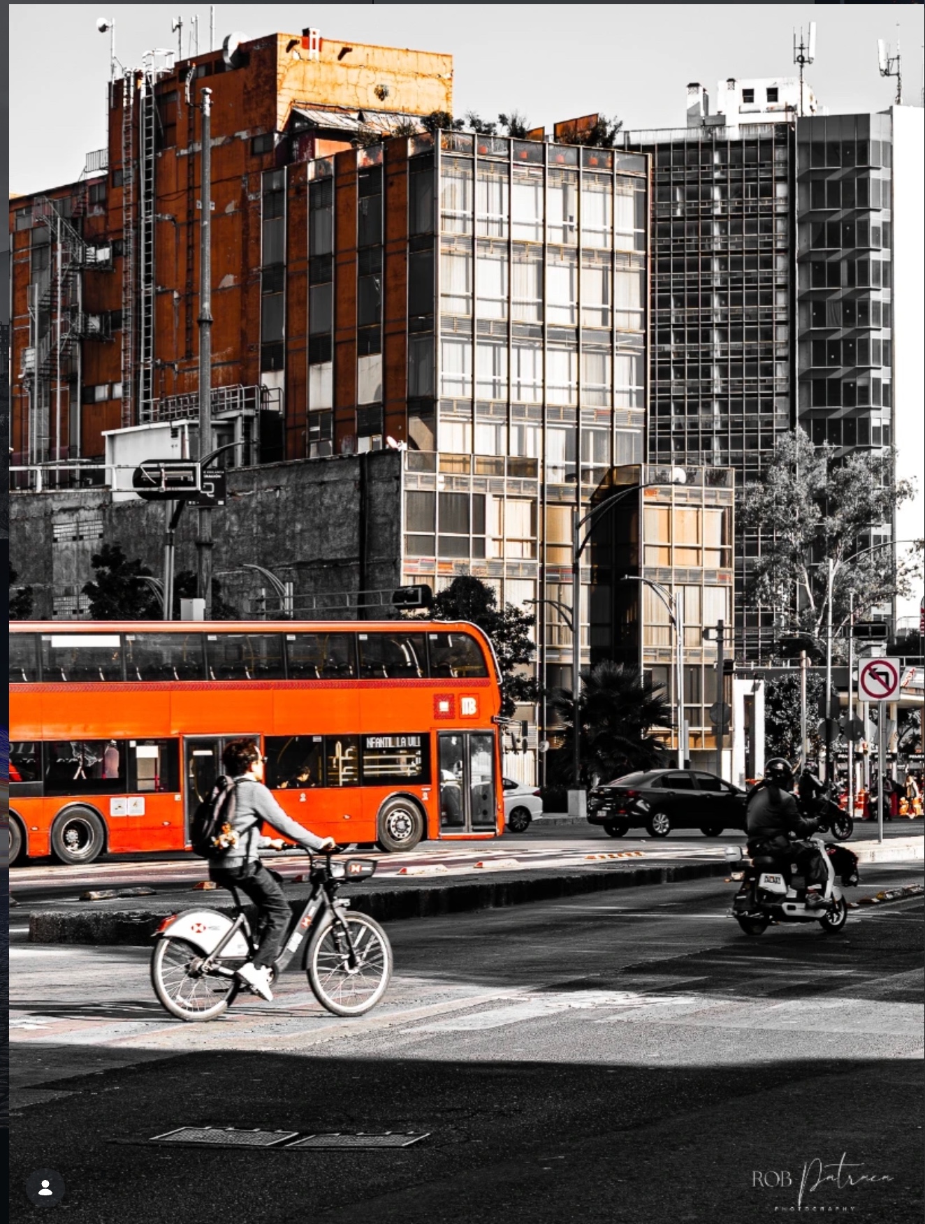 Double-decker bus in selective color against urban architecture